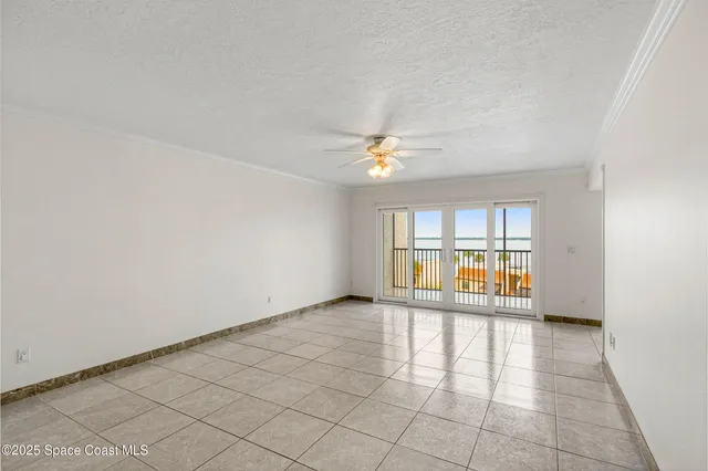 an empty room with windows and ceiling fan