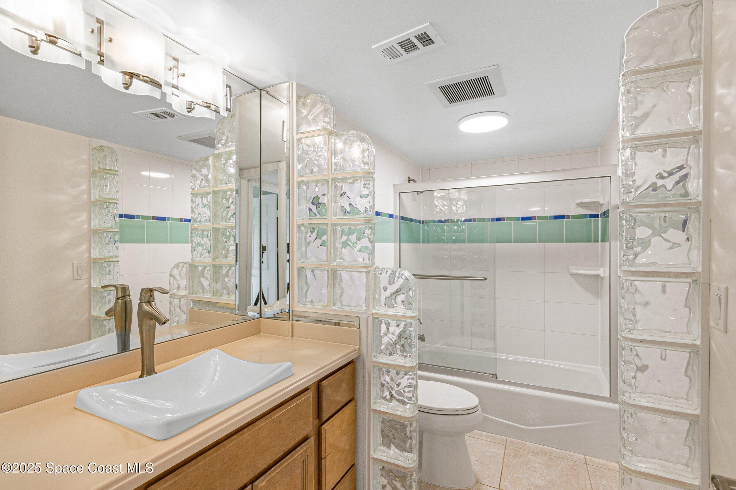 115 Indian River Drive, Unit 327 Cocoa, FL 32922 - Photo 23 of 47 a bathroom with a granite countertop sink a toilet a mirror and shower