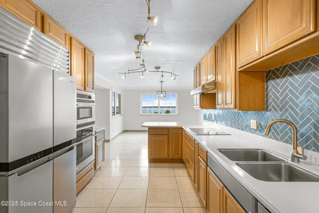 a kitchen with a sink refrigerator and cabinets