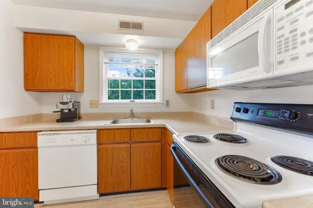a kitchen with a sink a stove and cabinets