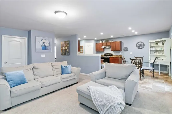 a living room with furniture and kitchen view
