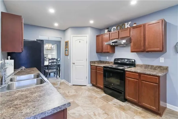 a kitchen with stainless steel appliances granite countertop a stove a sink and a refrigerator