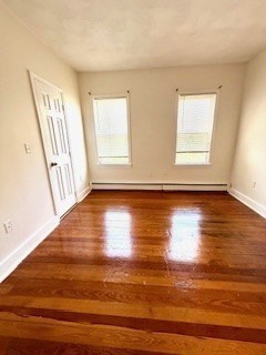 38 Hecla Street, Unit 1 Boston, MA 02122 - Photo 5 of 7 an empty room with wooden floor and windows