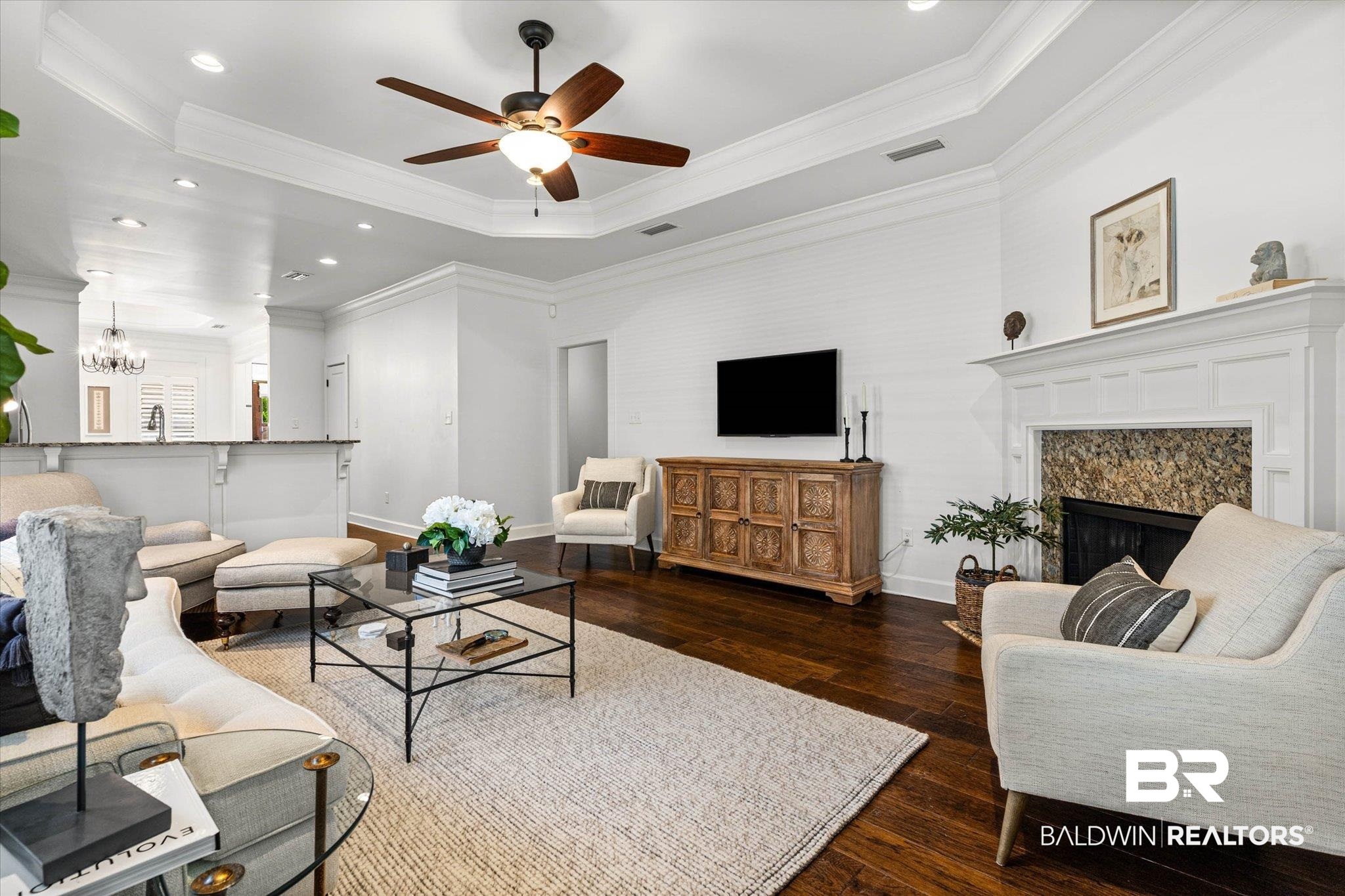 1052 Linlen Avenue Mobile, AL 36609 - Photo 9 of 22 Living area featuring dark wood-type flooring, a high end fireplace, a raised ceiling, crown molding, and ceiling fan