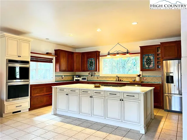 a kitchen with stainless steel appliances granite countertop a stove a sink and a refrigerator