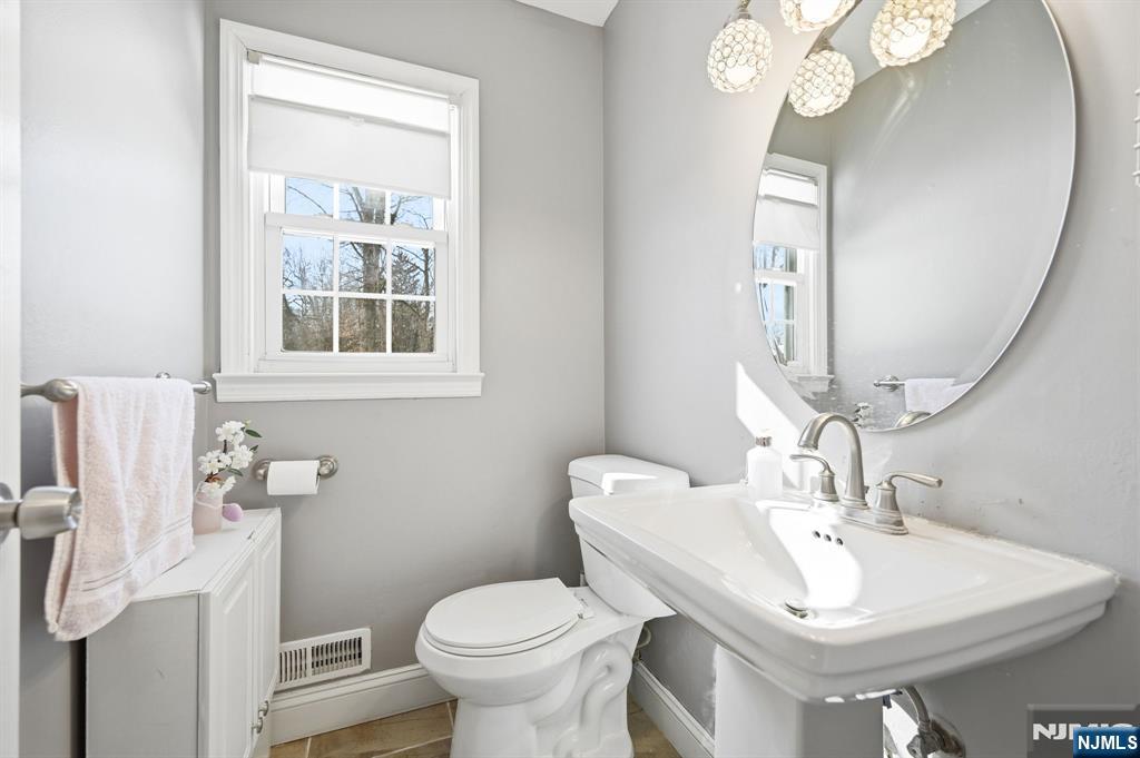 26 East Harrison Place Livingston, NJ 07039 - Photo 24 of 42 a bathroom with a sink a toilet and a mirror