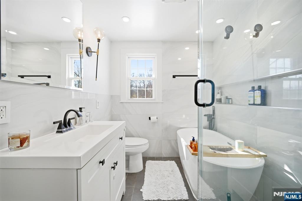 26 East Harrison Place Livingston, NJ 07039 - Photo 31 of 42 a bathroom with a sink toilet a mirror and shower