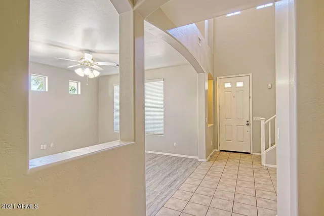 a view of a hallway with a chandelier fan and a living room view