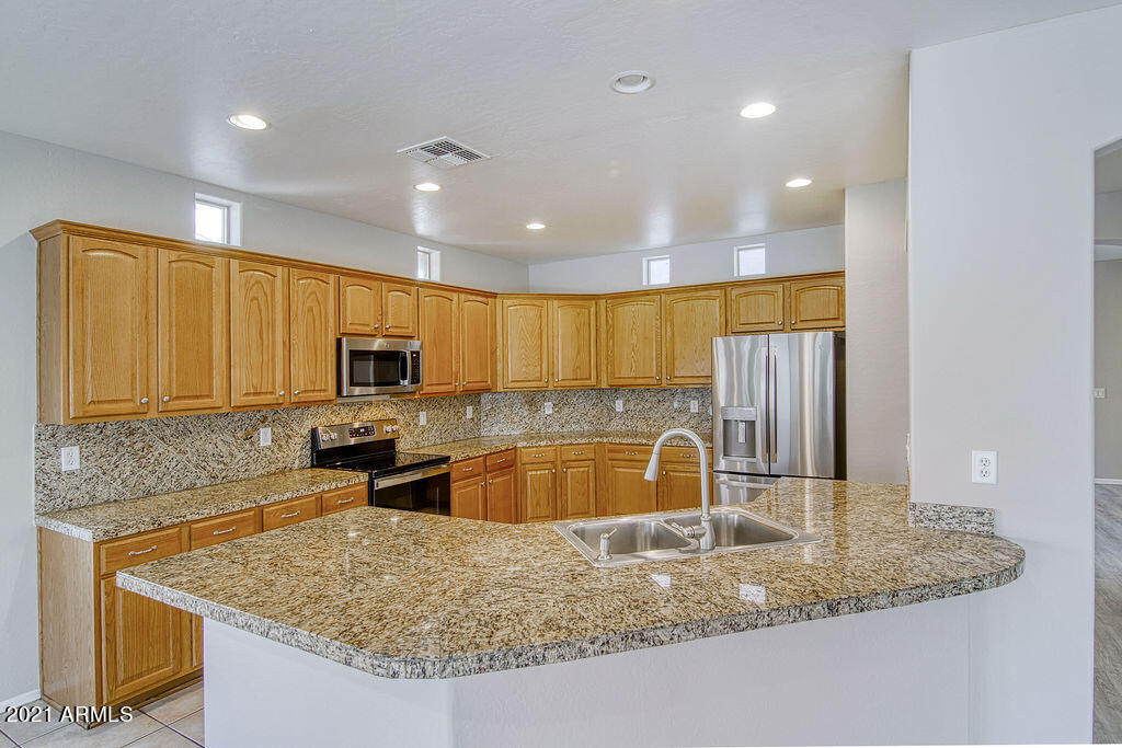 35210 North 30th Drive Phoenix, AZ 85086 - Photo 10 of 37 a kitchen with stainless steel appliances granite countertop a sink a stove and a refrigerator