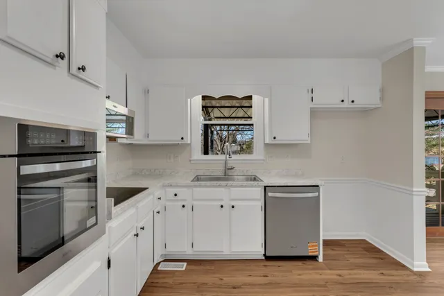 a kitchen with cabinets stainless steel appliances and a counter space