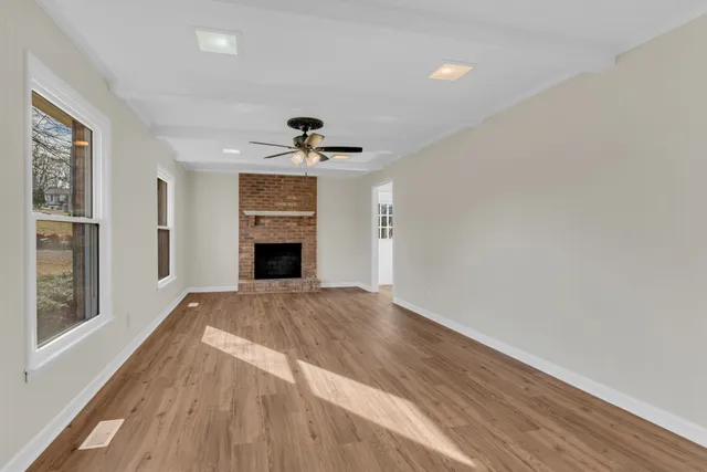 a view of an empty room with a fireplace and a window