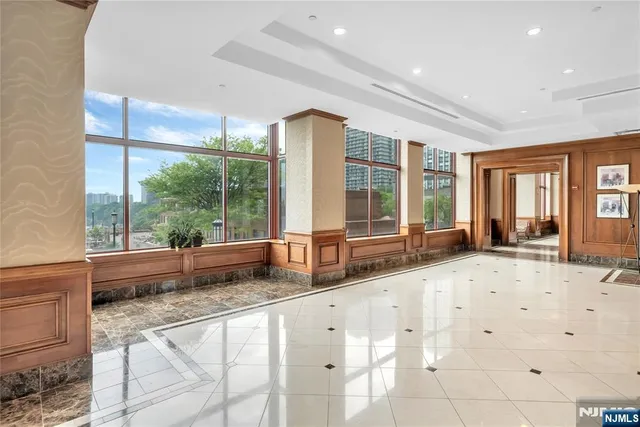 a large white kitchen with granite countertop a large window