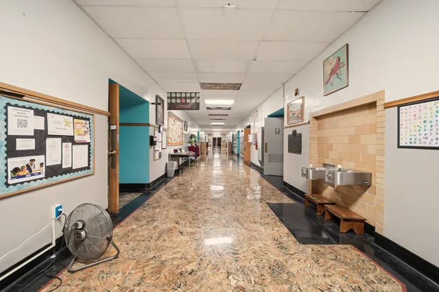 a hallway with a white stove top oven a dining table and chairs with wooden floor