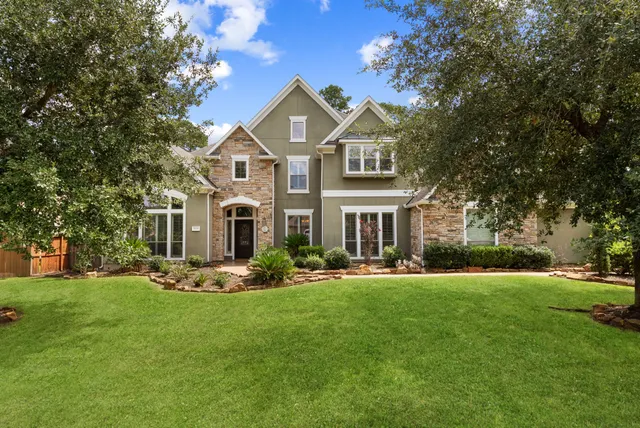 front view of a house with a yard and an trees