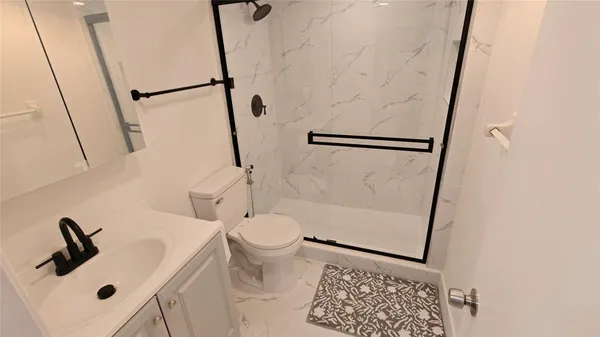 a bathroom with a sink toilet and shower