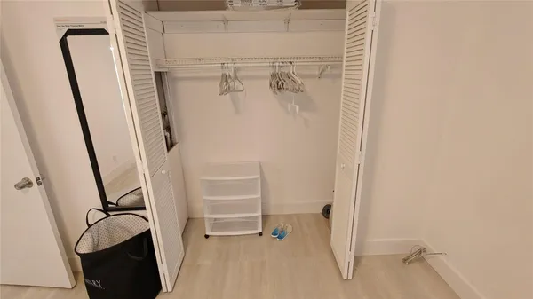 a view of walk in closet with empty racks