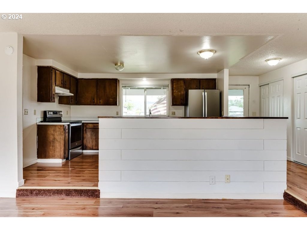 5265 F Street Springfield, OR 97478 - Photo 5 of 17 a large white kitchen with kitchen island a sink stainless steel appliances and cabinets