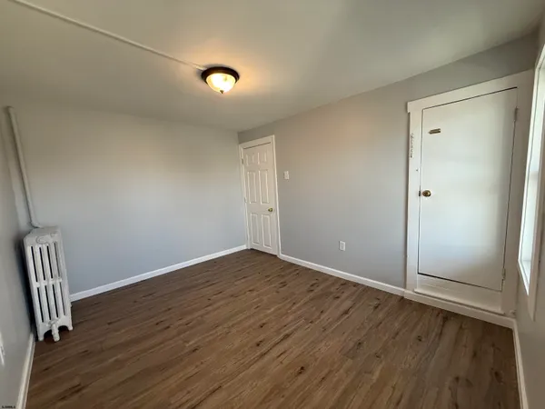 an empty room with wooden floor and air conditioner