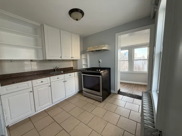 a kitchen with a stove cabinets and a refrigerator