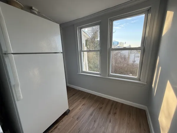 a view of a small space with wooden floor and a window