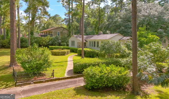 a view of a house with a yard and potted plants