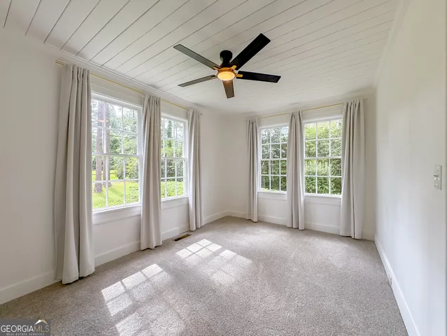 a view of empty room with a fireplace and window
