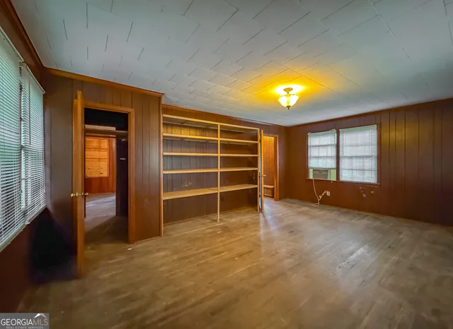 a view of a hallway with wooden floor and closet area