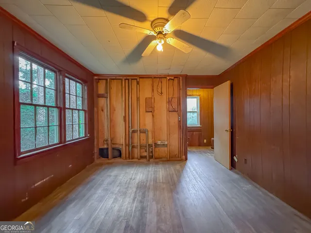 a view of a hallway with wooden floor and closet