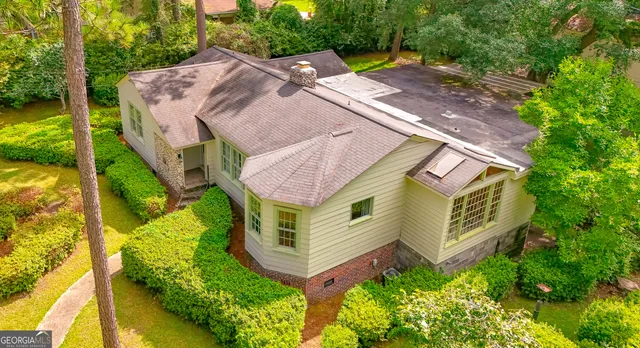 an aerial view of residential house with outdoor space and trees all around