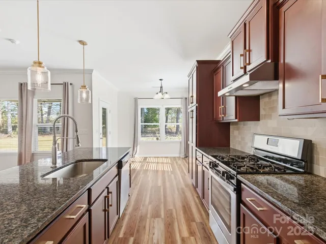 a kitchen with granite countertop a stove and a sink