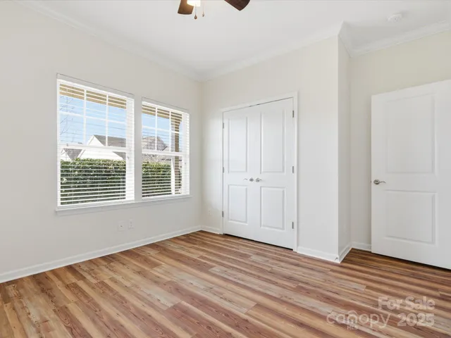 a view of an empty room with a window and a ceiling fan