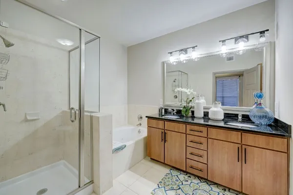 a bathroom with a double vanity sink mirror and shower