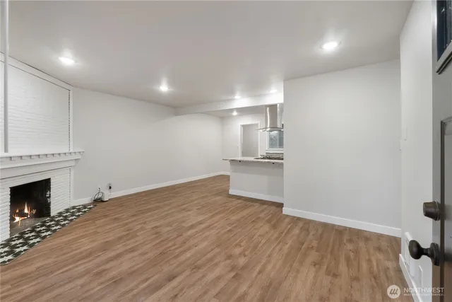 a view of empty room with wooden floor and fireplace
