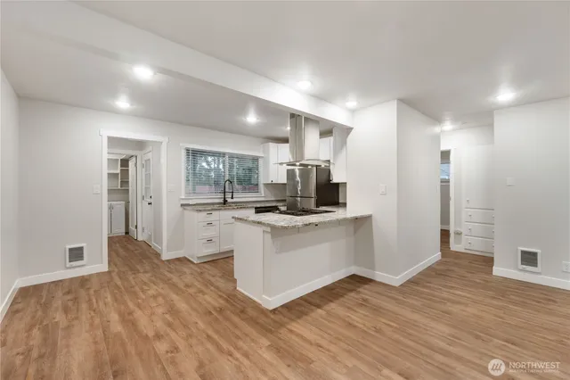 a open kitchen with white cabinets and stainless steel appliances