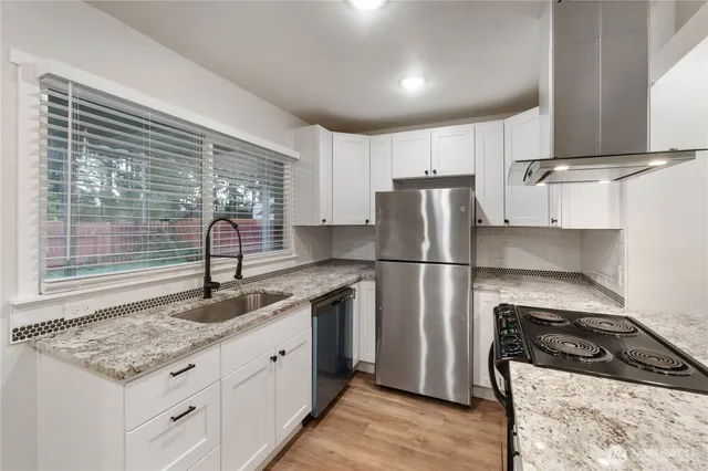 a kitchen with kitchen island granite countertop a sink appliances cabinets and counter space