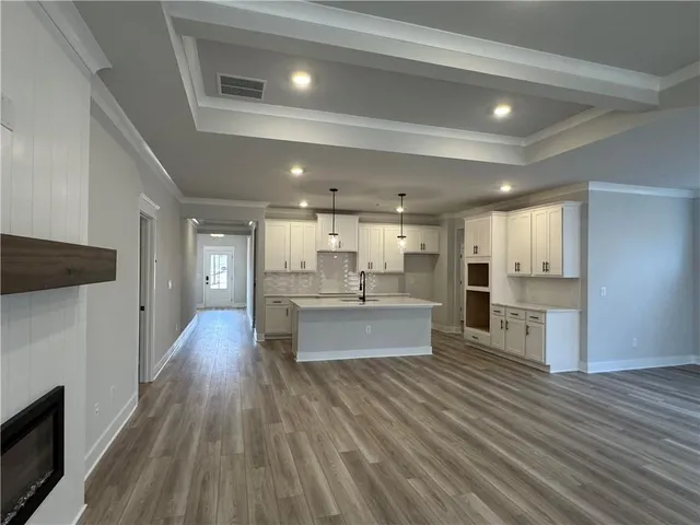 a view of kitchen with kitchen island wooden floor center island and stainless steel appliances