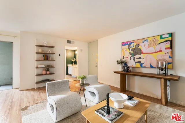 a living room with furniture a flat screen tv and kitchen view