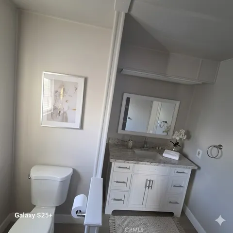 a kitchen with stainless steel appliances granite countertop a refrigerator a sink a stove and white cabinets