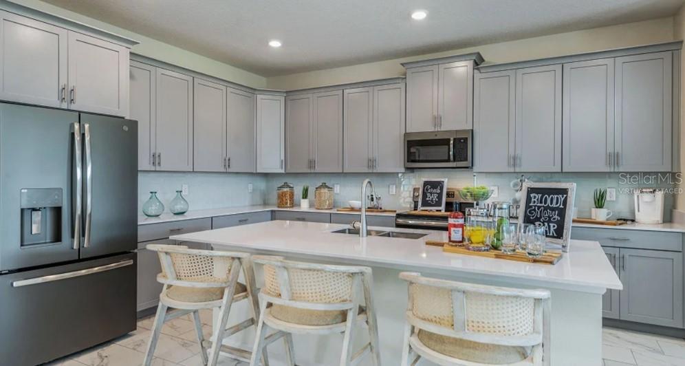 7855 Poplin Street Kissimmee, FL 34747 - Photo 2 of 15 a kitchen with a sink a microwave and refrigerator
