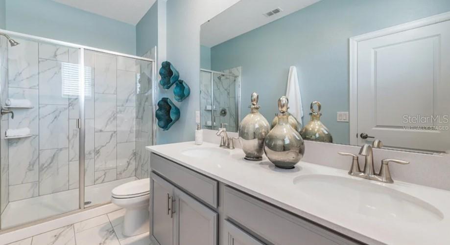 7855 Poplin Street Kissimmee, FL 34747 - Photo 7 of 15 a bathroom with a granite countertop sink a toilet and shower