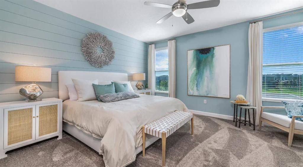 7855 Poplin Street Kissimmee, FL 34747 - Photo 8 of 15 a spacious bedroom with a bed and a chandelier