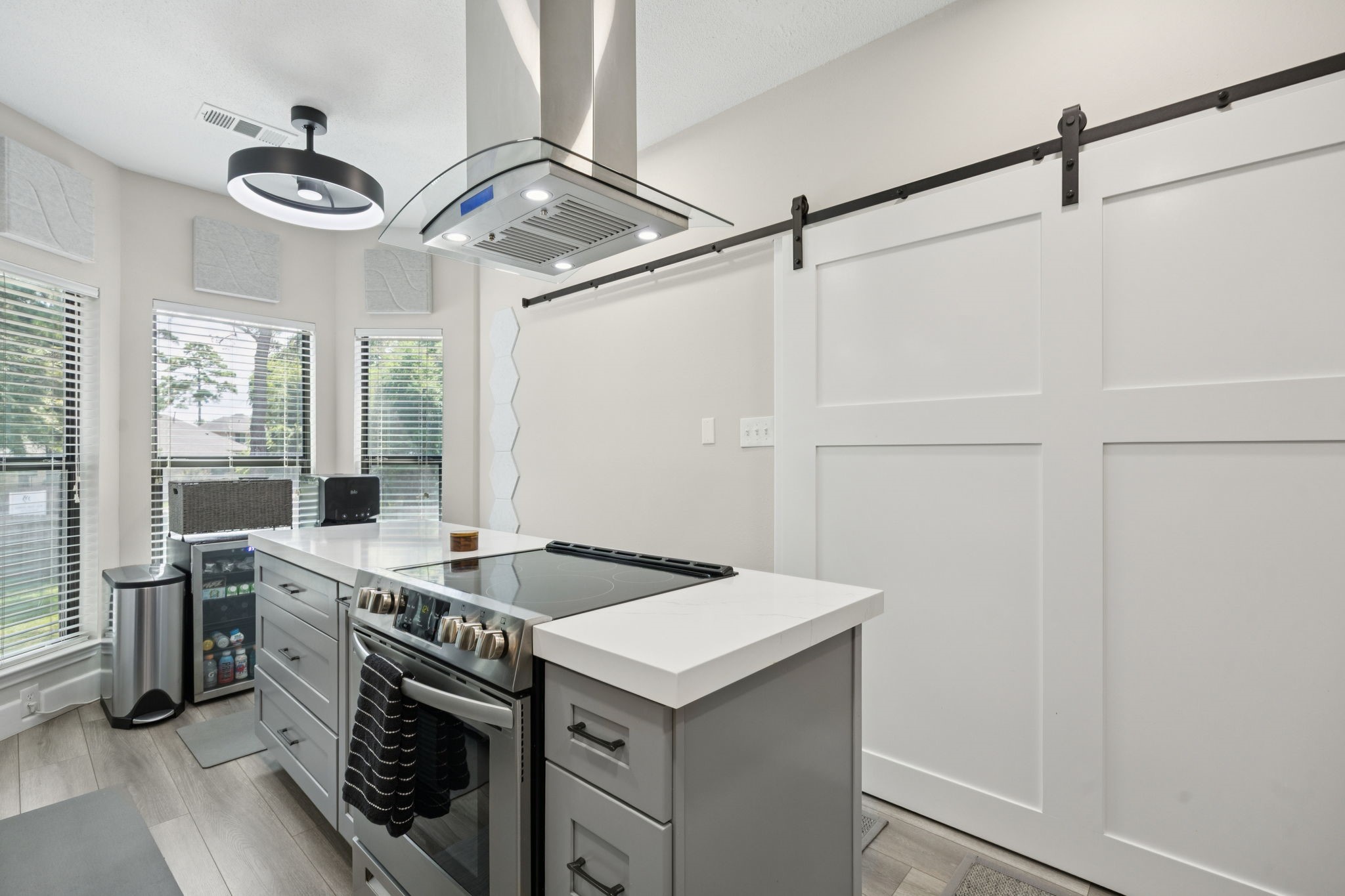 500 River Road, Unit 106 Montgomery, TX 77356 - Photo 13 of 32 A chef's dream kitchen featuring an electric stove with a large vent hood, abundant pull-out drawer storage, and three oversized windows that flood the space with natural light.