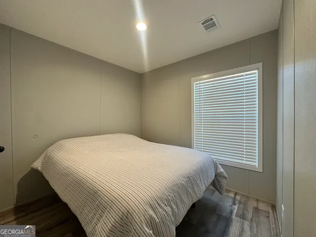 a large bed sitting in a bedroom next to a window