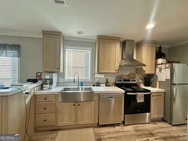 a kitchen with stainless steel appliances a sink stove and refrigerator