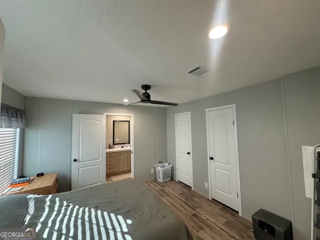 a bedroom with a bed and wooden floor