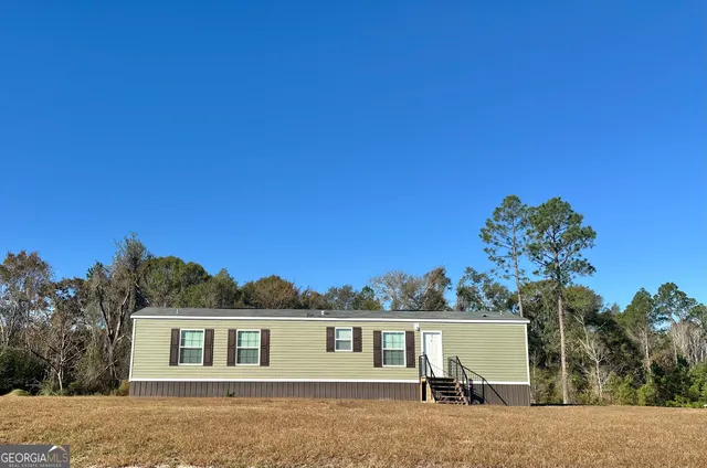 a view of a house with a backyard and a tree