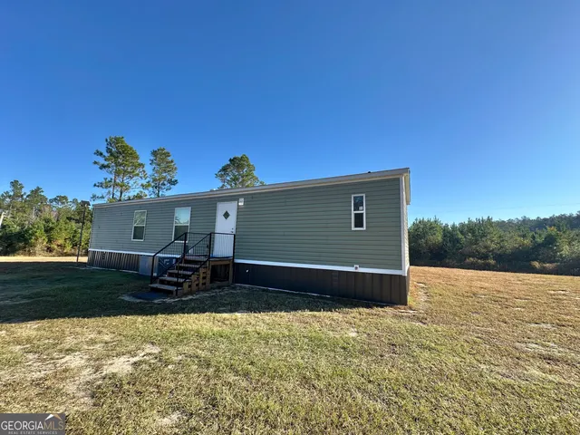 a backyard of a house with table and chairs