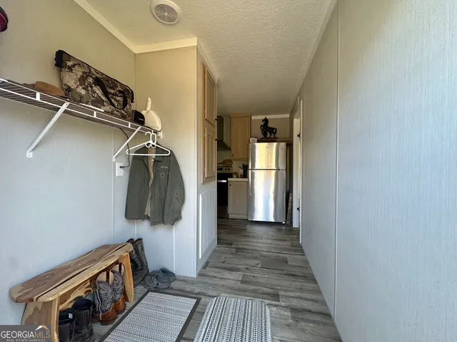 a walk in closet with wooden floor