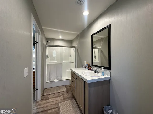 a bathroom with a sink mirror and shower