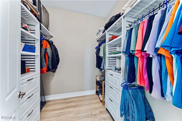 a view of walk in closet with clothes and shoes